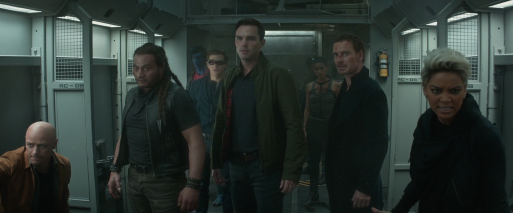 From left to right, Charles, Ariki, Kurt, Scott, Hank, Selene, Erik and Ororo face the camera in a train carriage as they are about to take down their enemy.